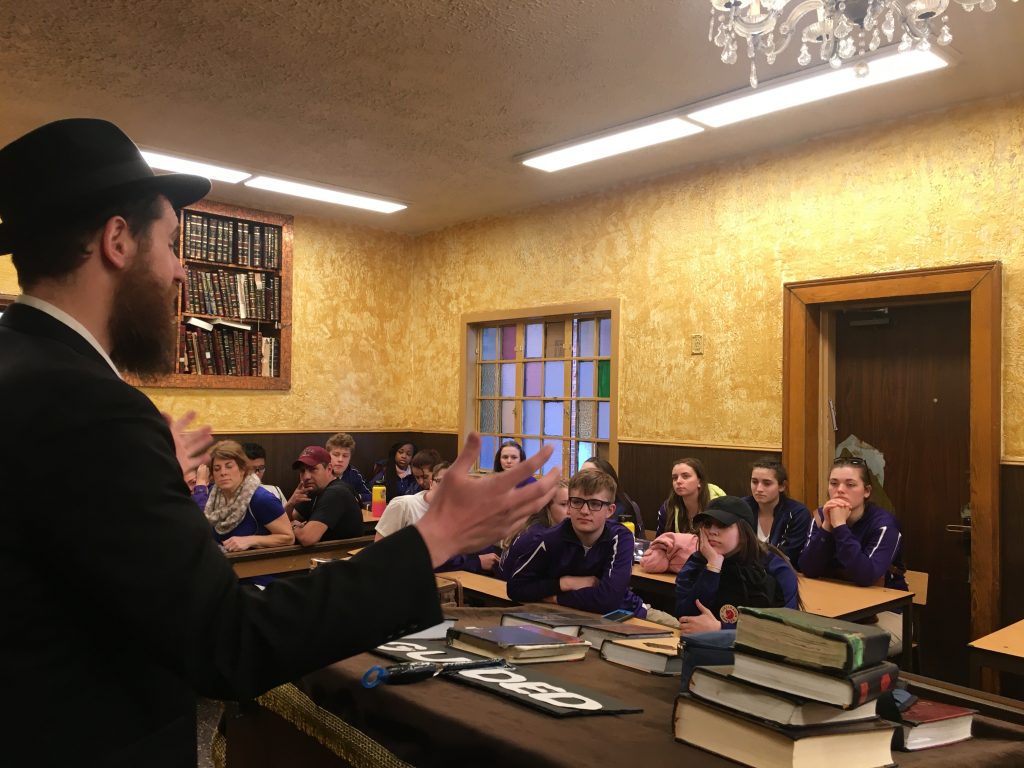 Photo of Rabbi Katz addressing students in the 770 Synagogue.