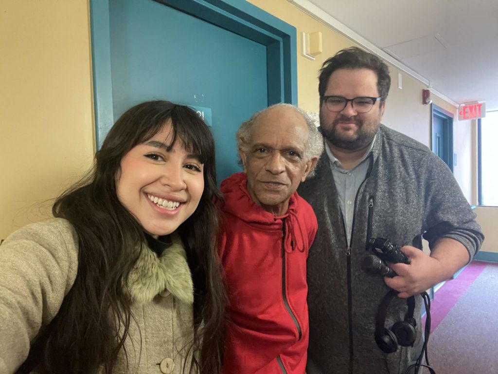 Selfie with Patrick Critton, in a red sweatsuit, sandwiched by Shoe Leather reporters Chantal Vaca, left, and Mike Davis, right.